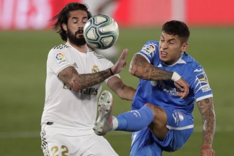 Getafe's Mathias Olivera, right, fights for the ball with Real Madrid's Isco during the Spanish La Liga soccer match between Real Madrid and Getafe at the Alfredo di Stefano stadium in Madrid, Spain, Thursday, July 2, 2020. (AP Photo/Bernat Armangue)