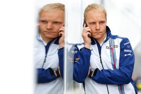 SPIELBERG, AUSTRIA - JUNE 20:  Valtteri Bottas of Finland and Williams speaks on his phone in the paddock during qualifying for the Formula One Grand Prix of Austria at Red Bull Ring on June 20, 2015 in Spielberg, Austria.  (Photo by Charles Coates/Getty Images)