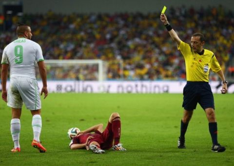 CURITIBA, BRAZIL - JUNE 26: Nabil Ghilas of Algeria is shown a yellow card by referee Cuneyt Cakir during the 2014 FIFA World Cup Brazil Group H match between Algeria and Russia at Arena da Baixada on June 26, 2014 in Curitiba, Brazil.  (Photo by Jamie Squire/Getty Images)