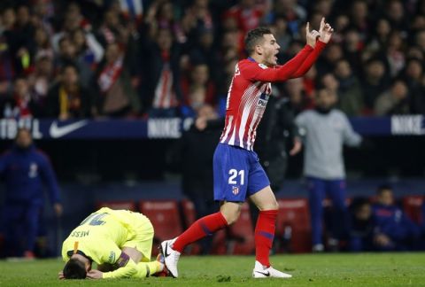 Atletico's Lucas Hernandez gestures to the referee after fouling Barcelona's Lionel Messi, left, during a Spanish La Liga soccer match between Atletico Madrid and FC Barcelona at the Metropolitano stadium in Madrid, Saturday, Nov. 24, 2018. (AP Photo/Paul White)