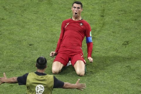 Portugal's Cristiano Ronaldo slides on his knees on the pitch as he celebrates after scoring his side's 2nd goal during the group B match between Portugal and Spain at the 2018 soccer World Cup in the Fisht Stadium in Sochi, Russia, Friday, June 15, 2018. (AP Photo/Thanassis Stavrakis)