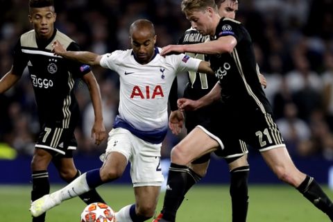 Tottenham's Lucas Moura, center, duels for the ball with Ajax's Frenkie de Jong, right, during the Champions League semifinal first leg soccer match between Tottenham Hotspur and Ajax at the Tottenham Hotspur stadium in London, Tuesday, April 30, 2019. (AP Photo/Kirsty Wigglesworth)