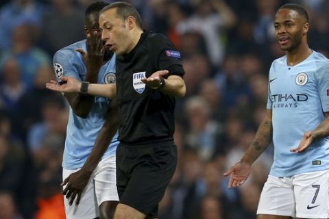 Turkish referee Cuneyt Cakir walks away after reviewing the VAR and giving a goal to Tottenham's Fernando Llorente as Manchester City's Benjamin Mendy, left, and Manchester City's Raheem Sterling, 7, continue to appeal for handball during the Champions League quarterfinal, second leg, soccer match between Manchester City and Tottenham Hotspur at the Etihad Stadium in Manchester, England, Wednesday, April 17, 2019. (AP Photo/Dave Thompson)