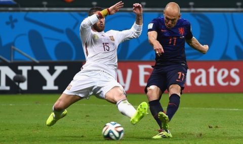SALVADOR, BRAZIL - JUNE 13:  Arjen Robben of the Netherlands shoots and scores his teams second goal as Sergio Ramos of Spain defends in the second half during the 2014 FIFA World Cup Brazil Group B match between Spain and Netherlands at Arena Fonte Nova on June 13, 2014 in Salvador, Brazil.  (Photo by David Ramos/Getty Images)