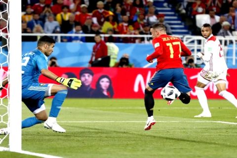 Spain's Iago Aspas, right, scores his side's second goal past Morocco goalkeeper Monir El Kajoui, during the group B match between Spain and Morocco at the 2018 soccer World Cup at the Kaliningrad Stadium in Kaliningrad, Russia, Monday, June 25, 2018. (AP Photo/Petr David Josek)