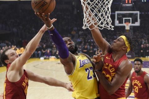 Los Angeles Lakers forward LeBron James, center, shoots as Indiana Pacers forward Bojan Bogdanovic, left, of Croatia, and center Myles Turner defend during the first half of an NBA basketball game Thursday, Nov. 29, 2018, in Los Angeles. (AP Photo/Mark J. Terrill)
