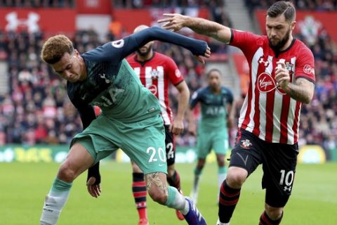 Tottenham Hotspur's Dele Alli, left, and Southampton's Charlie Austin battle for the ball during their English Premier League soccer match at St Mary's Stadium in Southampton, England, Saturday March 9, 2019. (Andrew Matthews/PA via AP)