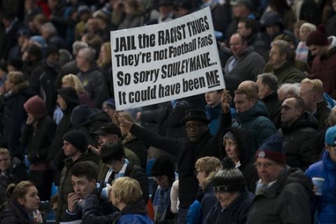 A supporter holds up an anti racism banner during the English Premier League soccer match between Manchester City and Newcastle at the Etihad Stadium, Manchester, England, Saturday Feb. 21, 2015. British police launched an investigation into suspected racism involving Chelsea fans, following an incident on Tuesday, Feb. 17, 2015 before a Champions League game at Paris Saint-Germain, where a black man named Souleymane S was filmed being blocked from boarding a metro train by Chelsea fans, who then chanted: "We're racist and that's the way we like it." (AP Photo/Jon Super)  