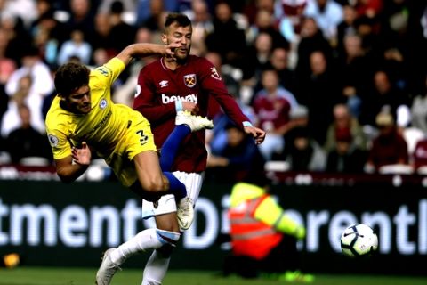 Chelsea's Marcos Alonso, left, vies for the ball with West Ham's Andriy Yarmolenko during the English Premier League soccer match between West Ham United and Chelsea at London Stadium in London, Sunday, Sept. 23, 2018. (AP Photo/Matt Dunham)
