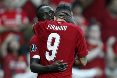 Liverpool's Sadio Mane celebrates with Roberto Firmino, right, after scoring his side's first goal during the UEFA Super Cup soccer match between Liverpool and Chelsea, in Besiktas Park, in Istanbul, Wednesday, Aug. 14, 2019. (AP Photo/Thanassis Stavrakis)