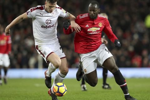 Burnley's Kevin Long, left, and Manchester United's Romelu Lukaku battle for the ball during their English Premier League soccer match at Old Trafford, Manchester, England, Tuesday, Dec. 26, 2017. (Martin Rickett/PA via AP)
