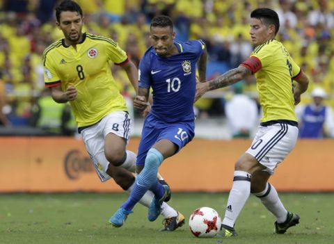 CORRECTS NAME FROM RADAMEL FALCAO TO JAMES RODRIGUEZ - Brazil's Neymar, center, fights for the ball with Colombia's Abel Aguilar, left, and James Rodriguez, during a 2018 Russia World Cup qualifying soccer match at the Roberto Melendez stadium in Barranquilla, Colombia, Tuesday, Sept. 5, 2017. (AP Photo/Fernando Vergara)