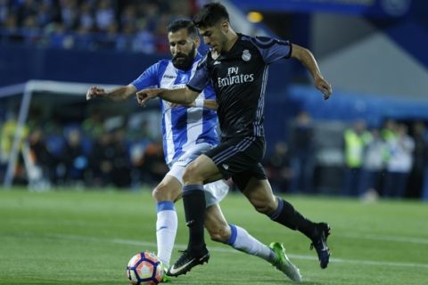 Real Madrid's Marco Asensio vies for the ball with Leganes' Dimitrios Siovas, left, during a Spanish La Liga soccer match between Leganes and Real Madrid at the Butarque stadium in Madrid, Wednesday, April 5, 2017. (AP Photo/Francisco Seco)
