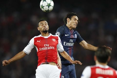 Arsenal's Francis Coquelin, left, and PSG's Edinson Cavani battle for a high ball during the Champions League group A soccer match group between Paris Saint Germain and Arsenal at the Parc des Princes stadium in Paris, Tuesday, Sept. 13, 2016. (AP Photo/Christophe Ena)