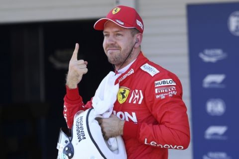 Ferrari driver Sebastian Vettel of Germany shows a number one sign after the qualifying session for the Japanese Formula One Grand Prix at Suzuka Circuit in Suzuka, central Japan, Sunday, Oct. 13, 2019. Vettel grabbed pole position. (AP Photo/Toru Takahashi)