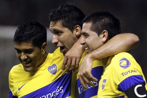 Boca Juniors' Juan Insaurralde (C) is embraced by teammates Franco Sosa (L) and Juan Roman Riquelme after scoring a goal against Godoy Cruz during their Argentine First Division soccer match in Buenos Aires, May 27, 2012.  REUTERS/Marcos Brindicci (ARGENTINA - Tags: SPORT SOCCER)