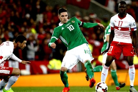Northern Ireland's Kyle Lafferty, center, is closed down during the World Cup qualifying play-off first leg soccer match between Northern Ireland and Switzerland at Windsor Park in Belfast, Northern Ireland, Thursday Nov. 9, 2017. (AP Photo/Peter Morrison)