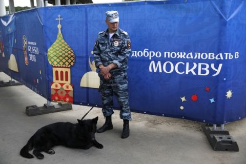 A police officer and his dog secure the perimeter prior to the opening match between Russia and Saudi Arabia during the 2018 soccer World Cup at the Luzhniki stadium in Moscow, Russia, Thursday, June 14, 2018. (AP Photo/Rebecca Blackwell)