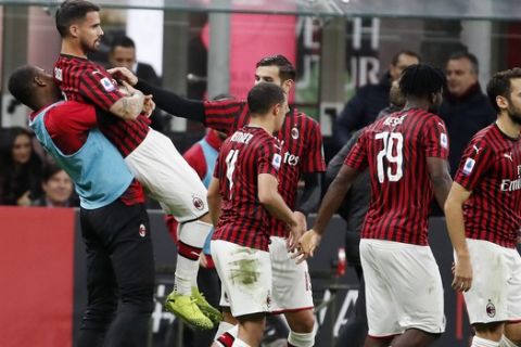 AC Milan's Suso, top left, celebrates with his teammates after scoring his side's opening goal during the Serie A soccer match between AC Milan and Spal at the San Siro stadium, in Milan, Italy, Thursday, Oct. 31, 2019. (AP Photo/Antonio Calanni)