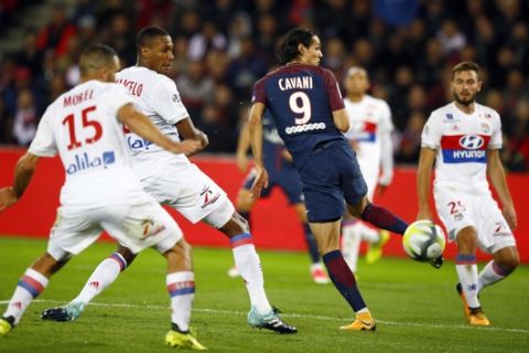 Paris Saint Germain's Edison Cavani, center, kicks the ball to score the first goal against Lyon during their French League One soccer match between PSG and Olympique Lyon at the Parc des Princes stadium in Paris, France, Sunday, Sept. 17, 2016. (AP Photo/Francois Mori)