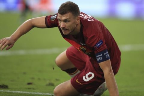 Roma's Edin Dzeko falls during an attempt to score during the Europa League, round of 16 soccer match between Roma and Sevilla, at the Schauinsland-Reisen-Arena in Duisburg, Germany, Thursday, Aug. 6, 2020. (Wolfgang Rattay/Pool Photo via AP)