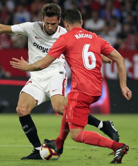 Real Madrid's Nacho, right, and Sevilla's Franco Vazquez, fight for the ball during La Liga soccer match between Sevilla and Real Madrid at the Sanchez Pizjuan stadium, in Seville, Spain on Wednesday, Sept. 26, 2018. (AP Photo/Miguel Morenatti)