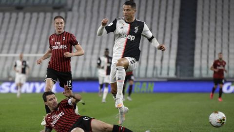 AC Milan's Alessio Romagnoli tackles Juventus' Cristiano Ronaldo during an Italian Cup second leg soccer match between Juventus and AC Milan at the Allianz stadium, in Turin, Italy, Friday, June 12, 2020. (AP Photo/Luca Bruno)
