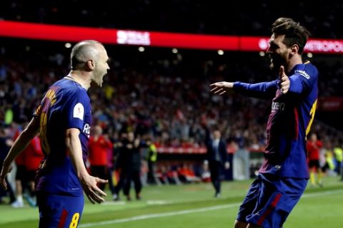 Barcelona's Andres Iniesta, left,, celebrates with Lionel Messi after scoring his side's fourth goal during the Copa del Rey final soccer match between Barcelona and Sevilla at the Wanda Metropolitano stadium in Madrid, Spain, Saturday, April 21, 2018. (AP Photo/Paul White)