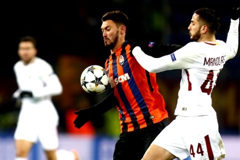 Roma's Kostas Manolas, right, duels for the ball with Shakhtar's Facundo Ferreyra during the Champions League, round of 16, first-leg soccer match between Shakhtar Donetsk and Roma at the Metalist Stadium in Kharkiv, Ukraine, Wednesday, Feb. 21, 2018. (AP Photo/Efrem Lukatsky)