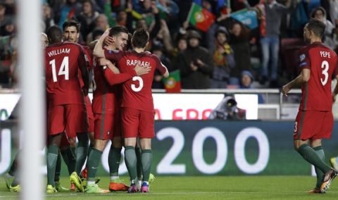 Portugal's Andre Silva, center left, is greeted by team mates as he celebrates after scoring a goal during the World Cup Group B qualifying soccer match between Portugal and Hungary at the Luz stadium in Lisbon Saturday, March 25 2017. (AP Photo/Armando Franca)