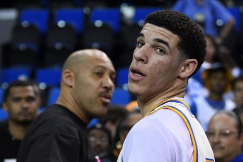FILE - In this Saturday, March 4, 2017, file photo, UCLA guard Lonzo Ball, right, walks away after hugging his father, LaVar, following the team's NCAA college basketball game against Washington State in Los Angeles. The UCLA freshman point guard has been one of college basketball's best players and could be the No. 1 pick in the NBA draft. He's kept up his high-level of play over the past month as his father, LaVar, has become more vocal in the media.  (AP Photo/Mark J. Terrill)