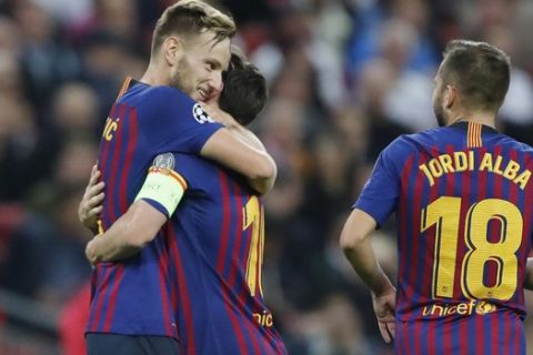 Barcelona midfielder Ivan Rakitic, left, celebrates with teammates Lionel Messi, center, and Jordi Alba, right, after scoring his sides second goal during the Champions League Group B soccer match between Tottenham Hotspur and Barcelona at Wembley Stadium in London, Wednesday, Oct. 3, 2018. (AP Photo/Frank Augstein)
