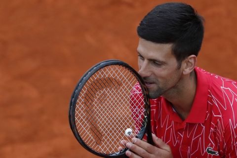 In this Friday, June 12, 2020 photo, Serbia's Novak Djokovic reacts during a tennis doubles match with Jelena Jankovic against Serbia's Nenad Zimonjic and Olga Danilovic at charity tournament Adria Tour, in Belgrade, Serbia. Novak Djokovic has tested positive for the coronavirus after taking part in a tennis exhibition series he organized in Serbia and Croatia. The top-ranked Serb is the fourth player to test positive for the virus after first playing in Belgrade and then again last weekend in Zadar, Croatia. His wife also tested positive. (AP Photo/Darko Vojinovic)