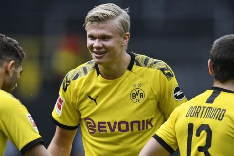 Dortmund's Erling Haaland, center, celebrates after his team scored the 4th goal during the German Bundesliga soccer match between Borussia Dortmund and Schalke 04 in Dortmund, Germany, Saturday, May 16, 2020. The German Bundesliga becomes the world's first major soccer league to resume after a two-month suspension because of the coronavirus pandemic. (AP Photo/Martin Meissner, Pool)