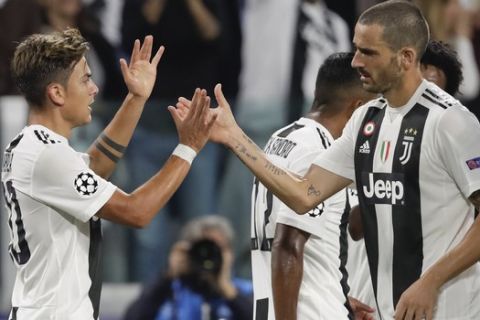 Juventus forward Paulo Dybala, left, celebrates with his teammate Leonardo Bonucci after scoring during the Champions League, group H soccer match between Juventus and Young Boys, at the Allianz stadium in Turin, Italy, Tuesday, Oct. 2, 2018. (AP Photo/Luca Bruno)