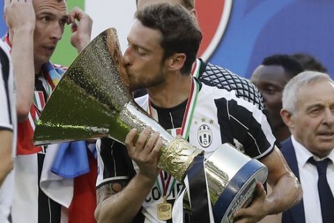 Juventus' Claudio Marchisio kisses the trophy as  Juventus players celebrate winning an unprecedented sixth consecutive Italian title, at the end of the Serie A soccer match between Juventus and Crotone at the Juventus stadium, in Turin, Italy, Sunday, May 21, 2017. (AP Photo/Antonio Calanni)