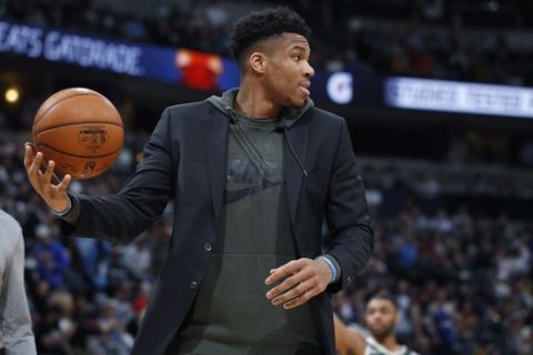 Milwaukee Bucks forward Giannis Antetokounmpo fields the ball as he shoots with teammates as they warm up for the second half of an NBA basketball game against the Denver Nuggets, Monday, March 9, 2020, in Denver. The Nuggets won 109-95. (AP Photo/David Zalubowski)