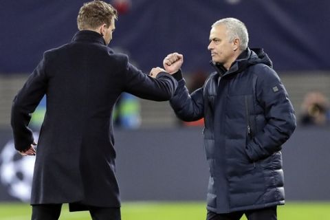 Tottenham's manager Jose Mourinho, right, and Leipzig's head coach Julian Nagelsmann touch their forearms instead of shaking hands due to the coronavirus after the Champions League round of 16, 2nd leg soccer match between RB Leipzig and Tottenham Hotspur in Leipzig, Germany, Tuesday, March 10, 2020. Leipzig defeated Tottenham with 3-0. (AP Photo/Michael Sohn)