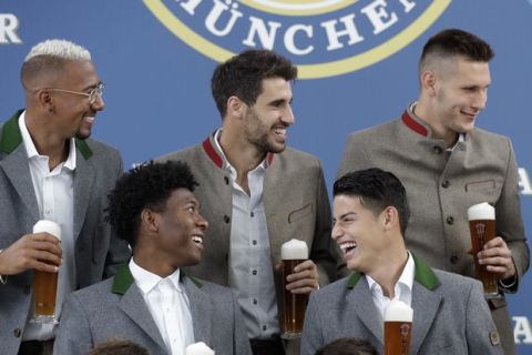 Bayern's Jerome Boateng, second row from left, Javi Martinez, Niklas Suele and David Alaba, first row left, and James Rodriguez laugh in traditional Bavarian clothes during a photo shooting of a brewing company in Munich, Germany, Wednesday, Sept. 13, 2017. Mueller celebrates his 28th birthday today. (AP Photo/Matthias Schrader)