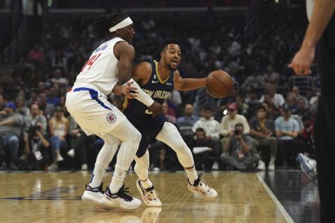 New Orleans Pelicans guard CJ McCollum, right, is blocked by Los Angeles Clippers guard Terance Mann during the first half of an NBA basketball game on Sunday, Oct. 30, 2022, in Los Angeles, Calif. (AP Photo/Allison Dinner)