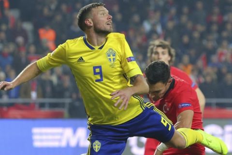 Sweden's Marcus Berg, left, and Turkey's Kaan Ayhan challenge for the ball during the UEFA Nations League soccer match between Turkey and Sweden in Konya, Turkey, Saturday, Nov. 17, 2018. (AP Photo)