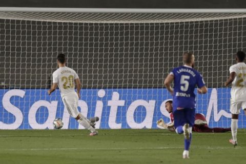 Real Madrid's Marco Asensio, left, scores during the Spanish La Liga soccer match between Real Madrid and Deportivo Alaves at the Alfredo di Stefano stadium in Madrid, Spain, Friday, July 10, 2020. (AP Photo/Bernat Armangue)