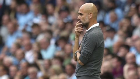 Manchester City coach Pep Guardiola follows the action from the touchline during the English Premier League soccer match between Manchester City and Newcastle United at the Etihad Stadium in Manchester, England, Saturday, Sept. 1, 2018. (AP Photo/Jon Super)