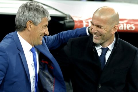 Las Palmas coach Quique Setien, left, and Real Madrid's head coach Zinedine Zidane greet each other before a Spanish La Liga soccer match between Real Madrid and Las Palmas at the Santiago Bernabeu stadium in Madrid, Spain, Wednesday March 1, 2017. (AP Photo/Paul White)