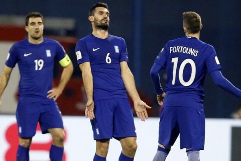 Greece's Alexandros Tziolis, center, and Kostas Fortounis react during the World Cup qualifying play-off first leg soccer match between Croatia and Greece at Maksimir Stadium in Zagreb, Thursday Nov. 9, 2017. (AP Photo/Darko Bandic)