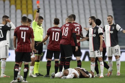 AC Milan's Ante Rebic, center, gets a red card during an Italian Cup second leg soccer match between Juventus and AC Milan at the Allianz stadium, in Turin, Italy, Friday, June 12, 2020. The match was being played without spectators because of the coronavirus lockdown. (AP Photo/Luca Bruno)