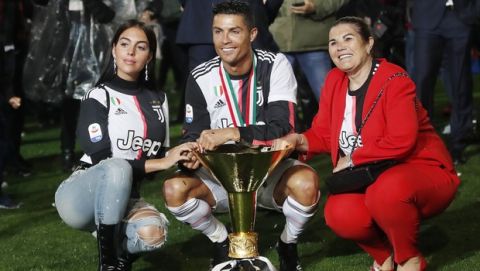 Juventus' Cristiano Ronaldo, center, is flanked by his girlfriend Georgina, left, and his mother Dolores Aveiro, right, pose with the Serie A soccer title trophy, at the Allianz Stadium, in Turin, Italy, Wednesday, April 3, 2019. (AP Photo/Antonio Calanni)