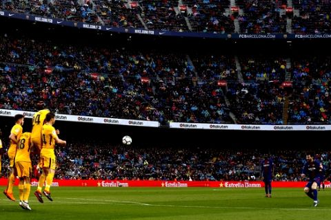 FC Barcelona's Lionel Messi, right, shoots a free kick during the Spanish La Liga soccer match between FC Barcelona and Atletico Madrid at the Camp Nou stadium in Barcelona, Spain, Sunday, March 4, 2018. (AP Photo/Manu Fernandez)