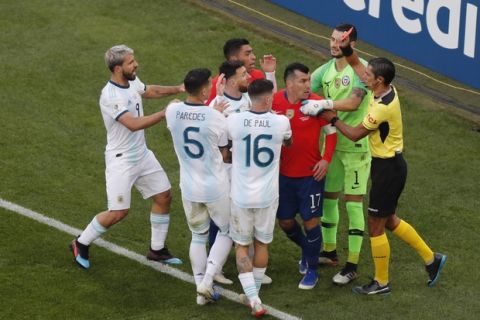 Referee Mario Diaz, right, shows the red card to Argentina's Lionel Messi and Chile's Gary Medel during the Copa America third-place soccer match at the Arena Corinthians in Sao Paulo, Brazil, Saturday, July 6, 2019. (AP Photo/Nelson Antoine)