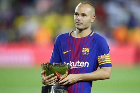 FC Barcelona's Andres Iniesta holds the Joan Gamper trophy after a friendly soccer match between FC Barcelona and Chapecoense at the Camp Nou stadium in Barcelona, Spain, Monday, Aug. 7, 2017. FC Barcelona defeated Chapecoense. (AP Photo/Manu Fernandez)